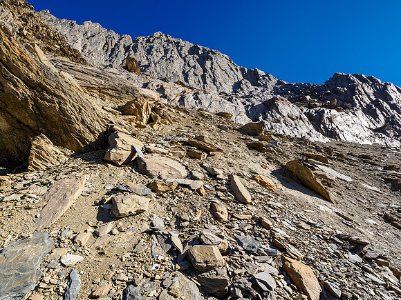 The SE traverse and break to the south ridge visible high above to the right under the summit cliff.