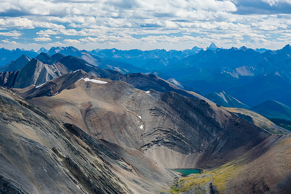Mount Assiniboine in the far distance over the small tarn.