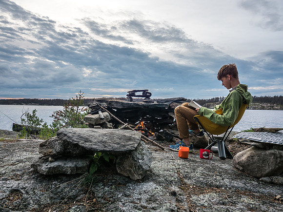 Reading by the fire as evening settles in around us on Wrist Lake. Once again, we have a whole back country lake all to ourselves.