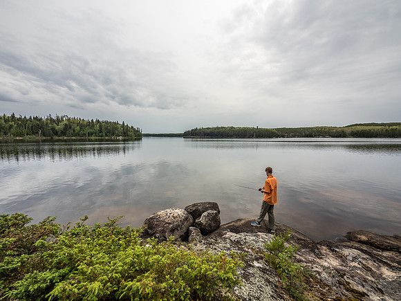 A perfectly calm lake in the late afternoon with rain clouds moving towards us quickly.