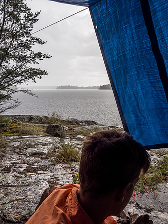 All hell breaks loose around us as we huddle under a very hastily set up tarp.
