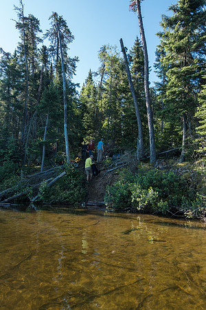 Looking back at the others as they prepare to launch their canoes at the steep landing site.