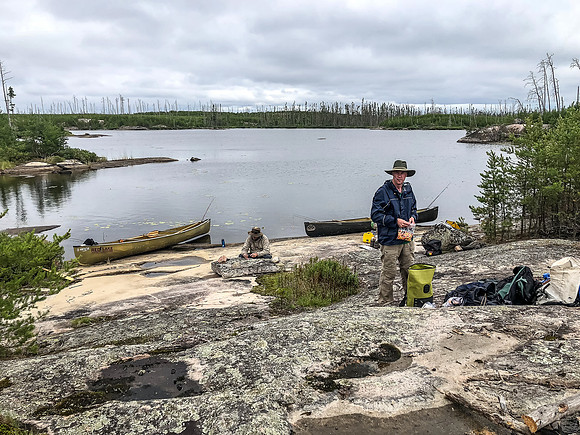 Rod with his trusty bag of Reese's Pieces and Hentie filleting Walleye in the background.