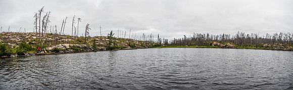 Looking back at the burnt shoreline near the end of the 825m portage into Wrist Lake as Hentie and Harold finish up their portage.