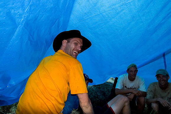 Huddled under a tarp.