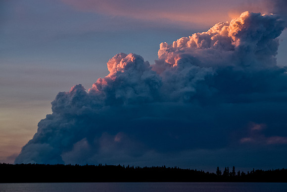 The smoke looks volcanic with the setting sun.