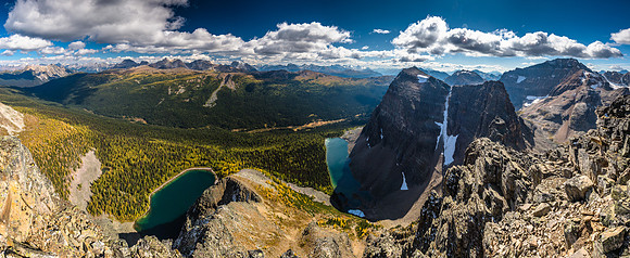 Greater and Middle Pharaoh Peaks rise dramatically over their namesake lake. Peaks such as Pilot, Brett, Black Brett and Bourgeau at distant left and center.
