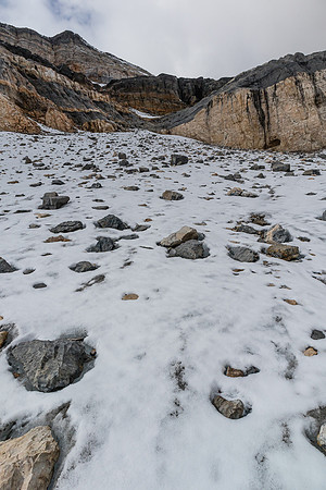 Ascending the debris covered glacier to the obvious break in the cliffs above.