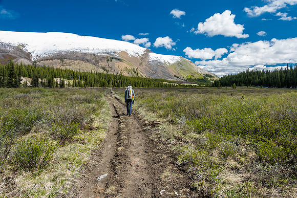 Hiking the South Ram River Trail back down river towards a snowy Finch Peak.
