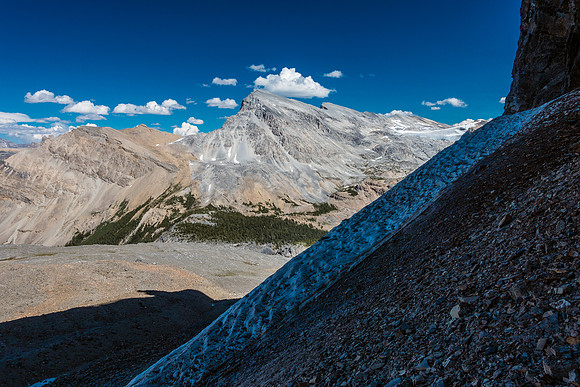 Looking over the permanent snow patch that I descended beside after traversing over the top ot it. The mountain in the background is Crowfoot.