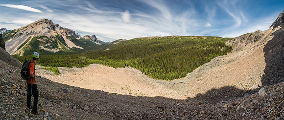 Phil observes the rest of our route from the bottom of the gully towards the trees and then following the treeline beside the rubble up to the Monarch Ramparts at upper right.