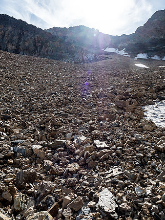 Looking up at the scree bowl to the summit block, we would follow the terrain as it curves left to meet the upper north ridge.