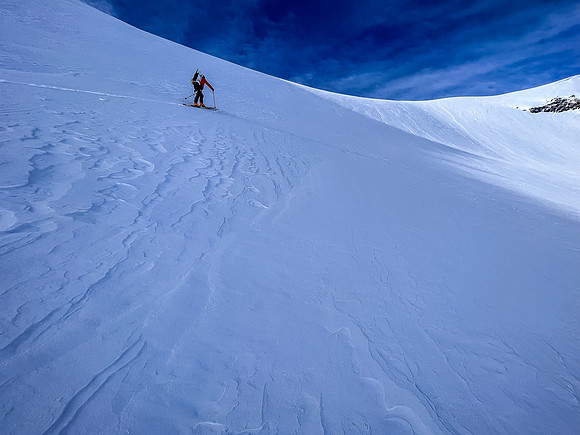 Skiing up the steep NE access slope to the south ridge above.