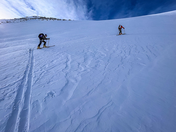 Skiing up the steep NE access slope to the south ridge above.