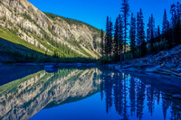 Looking back across the lake at the small stand of spruce which surround the fire ring and bivy site.