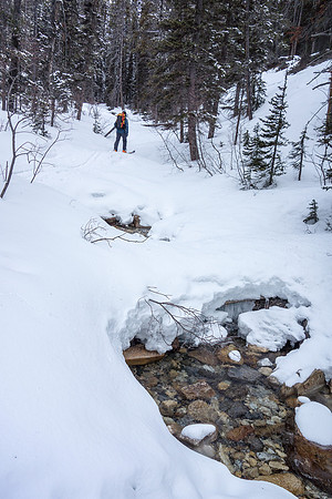 Wietse skis up the Chickadee Valley approach trail. Boom above him.