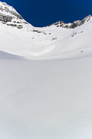 Starting to get nervous about the steep avy terrain ahead. We have to go straight up to that high col and beyond. The summit is still out of view.