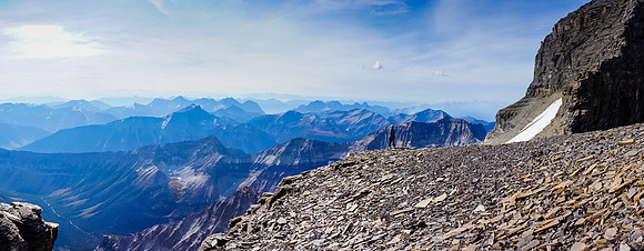 Kev on a shoulder of Lunette Peak underneath it's summit, Assiniboine's SW face rising behind him to the right.