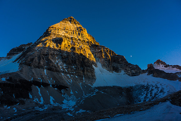 Mount Assiniboine with the moon as the sun sets. Our route goes up the ridge trending to skyline left from bottom left.