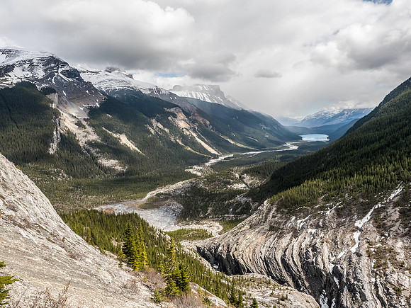 The Mons drainage at lower right and Glacier Lake in the far distance getting rain. Sullivan Peak and Mount Erasmus across the approach valley in clouds.