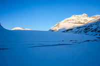 Castleguard Mountain peeks out above the glacier (center left). The large base camp is also visible on the lower right of the glacier toe.