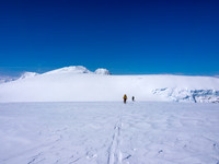 TJ and JW ski up Stutfield NE with Stutfield Peak, North Twin and Twins Tower poking up behind them