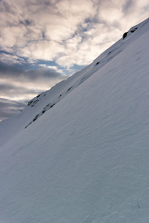 Looking back up and across the rock outcrop, showing the angle of the face as we descend.