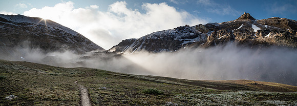 North Molar Pass wreathed in mist rises above the alpine meadows.