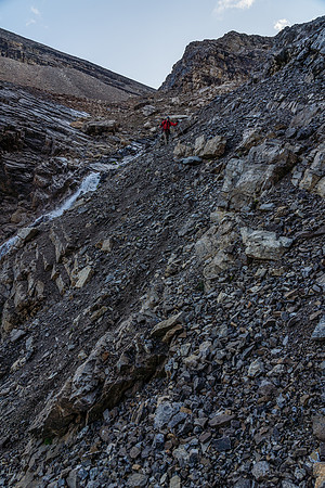 Descending steep rubble slopes to exit the headwall.