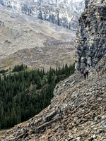Traversing a goat path along cliffs to the west to avoid wet bushwhacking.
