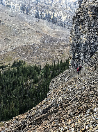 Traversing a goat path along cliffs to the west to avoid wet bushwhacking.
