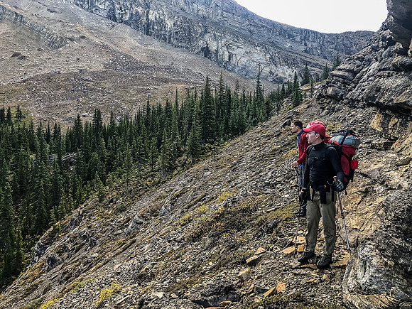 Traversing a goat path along cliffs to the west to avoid wet bushwhacking.