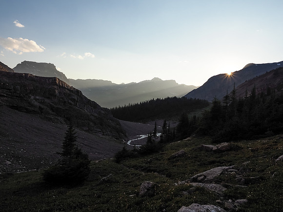 The sun sets over distant mountains in this view back down our approach valley from the bivy.
