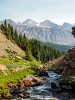 An energetic stream flows down towards the Fish Lakes. Deluc Peak rises in the far distance through the forest fire haze.