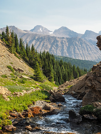 An energetic stream flows down towards the Fish Lakes. Deluc Peak rises in the far distance through the forest fire haze.