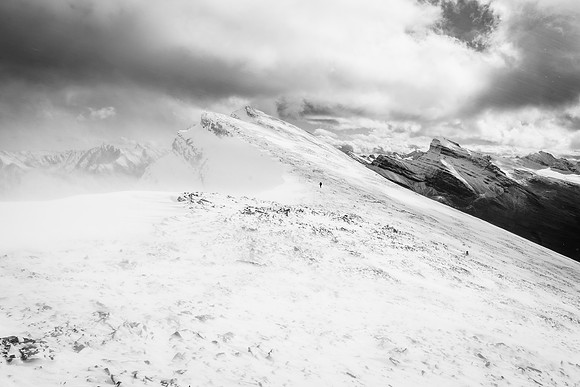 Phil follows me down the col while the wind whips up the loose snow around us.