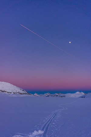 Our approach tracks with the moon and a plane catching the setting sun.