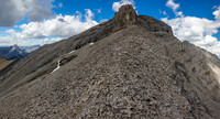 Looking up the key scree ledge to the summit block of Revenant Mountain.