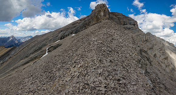 Looking up the key scree ledge to the summit block of Revenant Mountain.