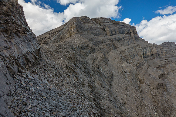 Looking up the key scree ledge to the summit block of Revenant Mountain.
