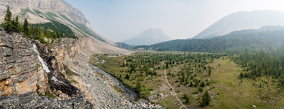 The Skoki Lakes trail snakes across the flats towards a barely visible Skoki Mountain and past Fossil Mountain on the right.