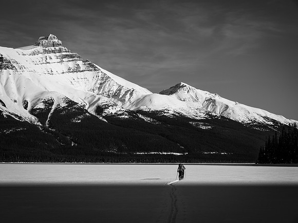 Finding the sun as we cross Hector Lake - Mount Hector rises over 1600 meters above us on the upper left.