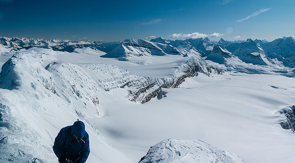 Looking down the steep snow face we ascended (L) and the Balfour Glacial Bench / Rock wall with Daly and Niles in the distance