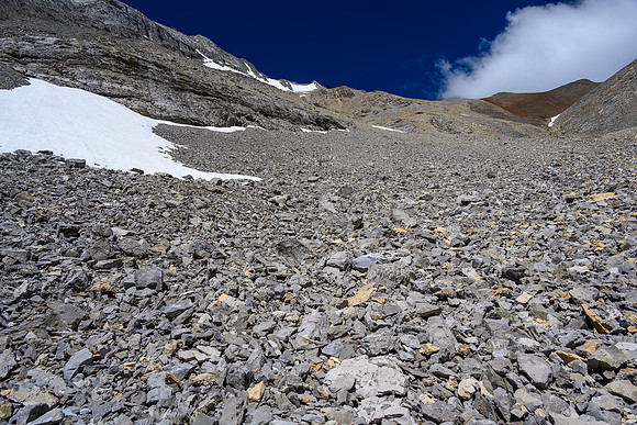 Ascending rubble slopes towards the summit just right of the distant snow patch.