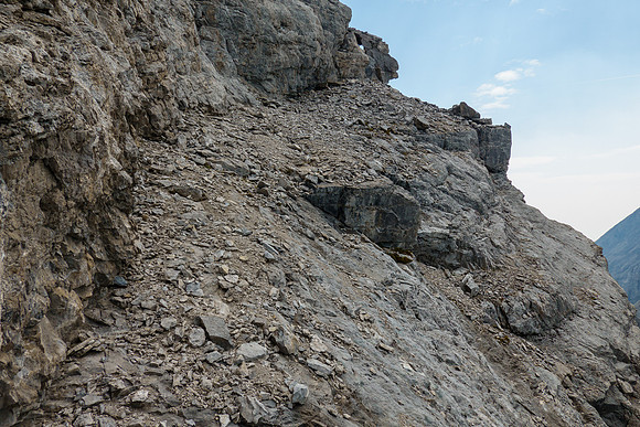 Traversing scree benches and ledges to the SE ridge along the upper south face. Note the window?