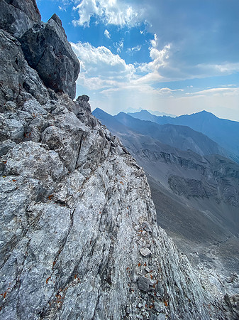 Traversing a tiny ledge just under the SE ridge crest.