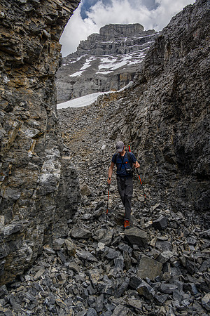 Wietse hikes through a small canyon with Solstice in the bg.