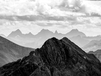 Looking over the dual summits of Norquay at the distant, unique shapes of the Verendrye Range (R) and Split Peak (L).