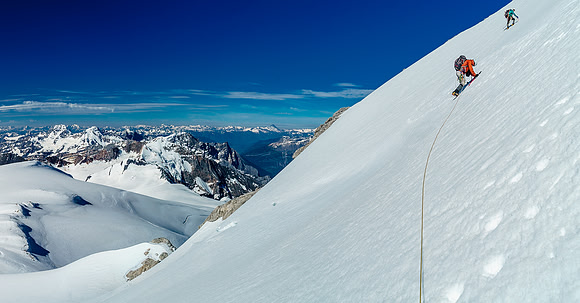 Ben traverses towards the bridge over the 'schrund on the southeast face of Christian Peak, the west shoulder that we approach from at lower left.