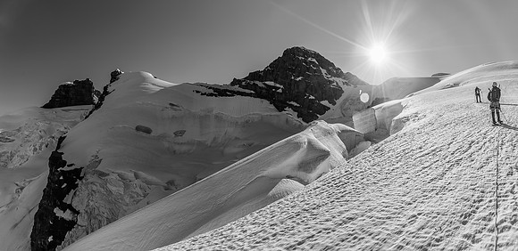 Heavily crevassed, sagging snow bridges and a traverse between two large 'schrunds that are shedding snow and ice over the route.